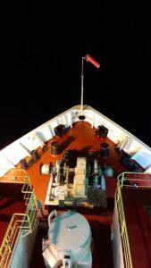 the bow of the ship lit up at night