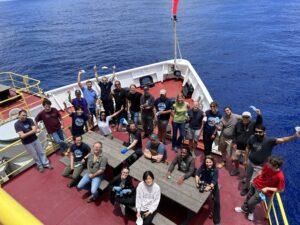 EXP391 gathers on the bow to celebrate the end of COVID mitigation protocols..