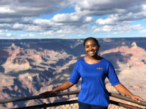 Sequoyah stands smiling at the camera with the Grand Canyon in the background.