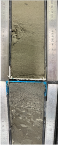two sediment cores are aligned top to bottom. the one below shows large clasts gradually fading to smaller clasts and sediment in a laminated pattern. Then the top core shows finer sediment in a laminated pattern.