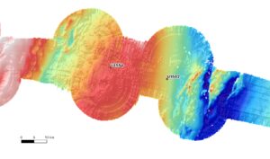 This image is a sonar map of the bottom of the ocean, it shows high ground in red and low ground in blue. There is a high area to the left and a low area to the right.
