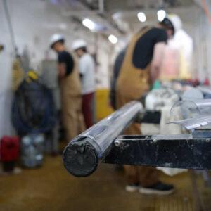 A core sits in focus while the technical support staff stands in the back of frame out of focus.